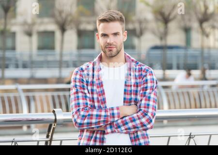 Fiducioso nella sua scelta. Vestito casual persona rilassarsi in città all'aperto. Maschio caucasico che riposa in strada. Concetto di vita moderna. Giovane uomo in camicia a scacchi. Uomo d'affari in piedi all'aperto. Foto Stock