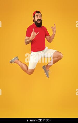 Carica di energia. Sano ragazzo sentirsi bene. Concetto ispirato. Sempre in movimento. Uno stile di vita attivo. Felice ragazzo che salta. Uomo con bearded attivo in movimento sfondo giallo. Hippster attivo ed energetico. Foto Stock