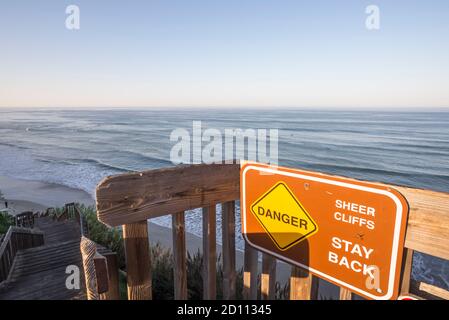 Cartello di pericolo in cima alla scala che scende a San Elijo state Beach. Encinitas, California, Stati Uniti. Foto Stock