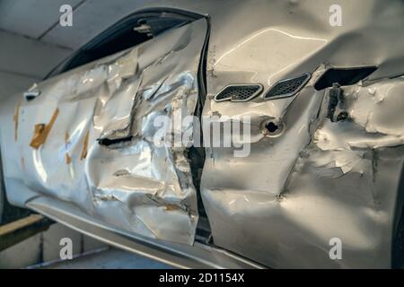 Auto sportiva rotta o danneggiata dopo un incidente stradale o un incidente in officina di riparazione, primo piano. Foto Stock