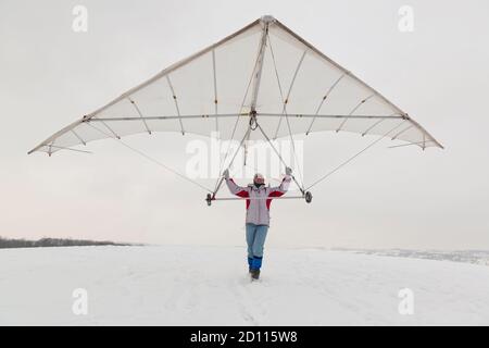 La ragazza tiene una vecchia ala deltaplano. Sogno di volare concetto. Foto Stock