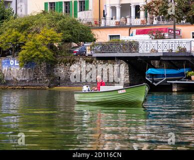 Pescatore in barca sul lago di Lugano. Tour culinario sul Lago di Lugano in Ticino, Circolo di Carona, Svizzera Foto Stock