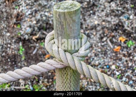 Corda spessa che è legata intorno ad un palo di legno Foto Stock