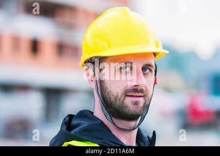 Un ingegnere che posa di fronte alla costruzione di un edificio è funzionamento di Foto Stock