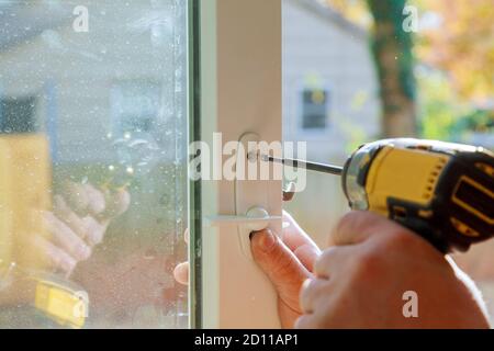 Manuale con un trapano a cacciavite per installare la serratura nella porta in una casa Foto Stock