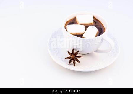 Cioccolata calda con marshmallow e anasone su sfondo bianco, vista dall'alto. Foto Stock