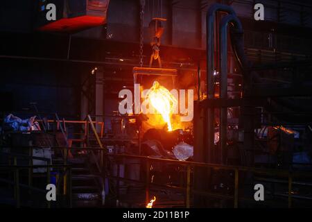 Processo di fusione di metalli in impianti metallurgici. Versamento di metallo liquido negli stampi Foto Stock