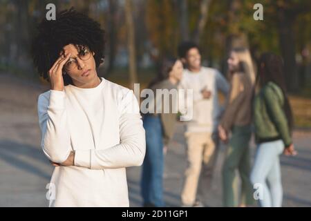 Triste adolescente africano che toccavola la testa, aveva litigato con gli amici Foto Stock