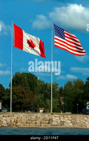L'americano e canadese bandiera volare fianco a fianco a Port Huron Michigan e Sarnia Ontario Canada Foto Stock