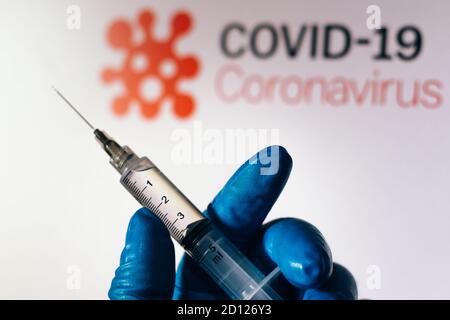 Brasile. 04 ottobre 2020. In questa illustrazione della foto la siringa medica è vista con il testo Covid-19 (Coronavirus) visualizzato su uno schermo in background Credit: SOPA Images Limited/Alamy Live News Foto Stock
