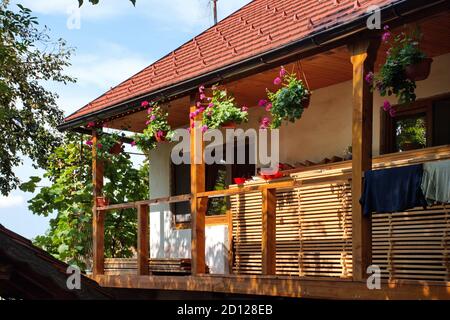 Cottage in una fattoria con recinzione in legno e piante in vaso sul portico Foto Stock