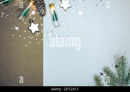 festivo nuovo anno sfondo a due colori decorato con rami di albero di natale, stelle d'argento e piccole bottiglie con gli alberi di natale ghirlanda Foto Stock