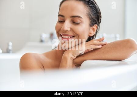 Bella giovane donna che si rilassa nella vasca da bagno a casa Foto Stock