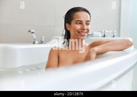 Bella giovane donna rilassante in vasca da bagno a casa Foto Stock