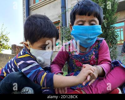 I bambini giocano indossando la maschera dopo il blocco del coronavirus nei paesi asiatici. Foto Stock