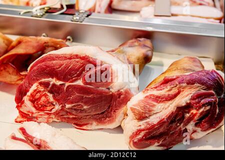 Selezione di carne di qualità in macelleria. Le nocche di maiale crudo sono in mostra. Assortimento di carne Foto Stock