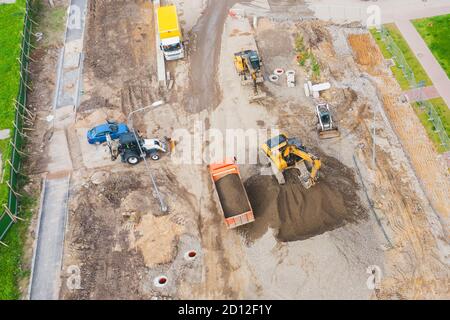 Costruzione di una strada urbana, posa di comunicazioni, installazione di botole fognarie, grondaie, cordoli. Preparazione per la pavimentazione, vista aerea Foto Stock