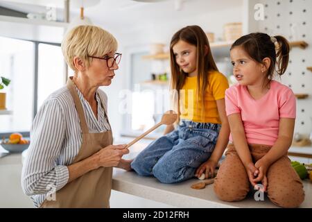 Nonna sta scolding le sue ragazze del grandchildrens. Famiglia, punizione, concetto di disciplina Foto Stock