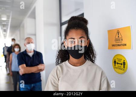 Ritratto di ragazza con maschera facciale, coronavirus, covid-19 e concetto di vaccinazione. Foto Stock