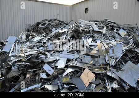 Sprechi di lamiera all'esterno della fabbrica di condotti. Serpentina in acciaio galvanizzato nella fabbrica di condotti. Rotoli confezionati di lamiera d'acciaio, bobine d'acciaio laminate a freddo. Foto Stock