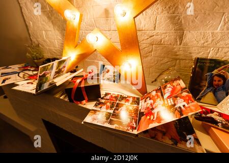 Prenota insieme vicino all'albero di Natale di fronte al caminetto Foto Stock