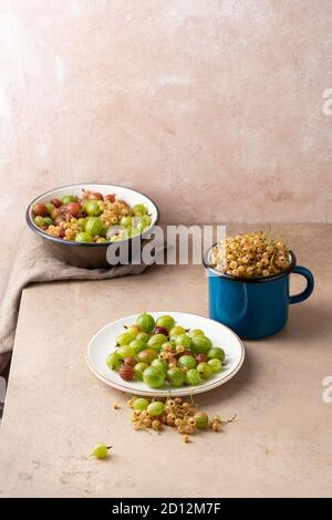 Bacche estive biologiche fresche da vicino su piatto e in tazza di smalto Foto Stock