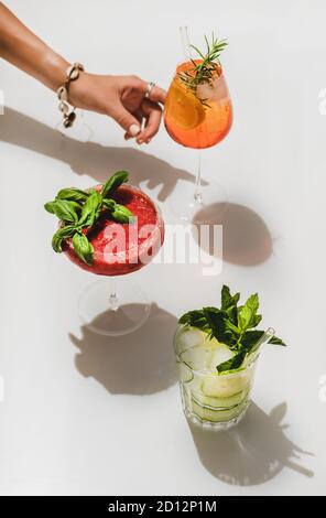 Margarita, Gin-tonic e Aperol Spritz vicino alle mani dei woman Foto Stock