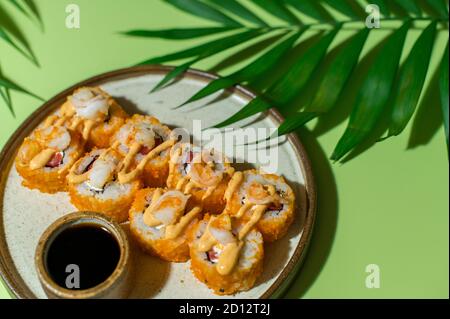 Panini con gamberi, formaggio cremoso, pomodori e salsa piccante. Cucina giapponese. Sfondo verde Foto Stock