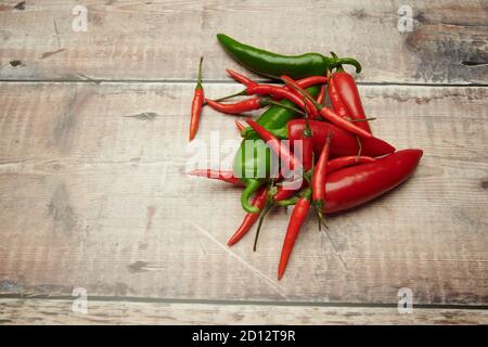 Peperoni (Capsicum frutescens) su un piano di lavoro di legno. Inghilterra, UK, GB, Foto Stock