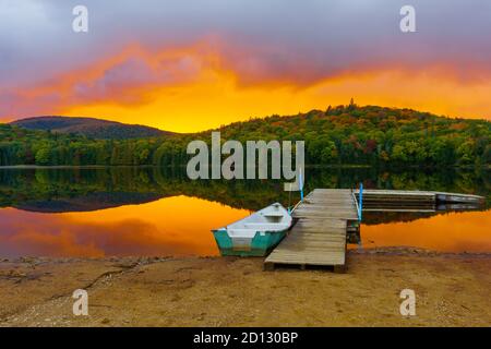 Barca e pier al tramonto in Petit Lac Monroe, Mont Tremblant NP, Quebec, Canada Foto Stock