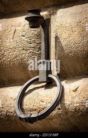 Antico anello in ferro battuto per legare con corda gli animali, i cavalli, i muli o i bovini, su un muro di pietra (ashlar). Firenze centro, Toscana, Italia. Foto Stock