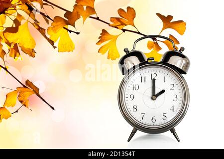 Orologio d'epoca e foglie di colori autunnali. Concetto di cambiamento dell'ora legale in autunno Foto Stock