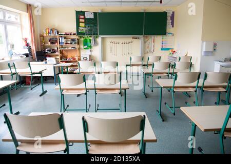 Lemwerder, Germania. 05 ottobre 2020. In una classe deserta di una scuola primaria le sedie sono poste in alto. Il distretto di Wesermarsch ha chiuso tutte le scuole, gli asili e i centri di assistenza diurna nella comunità di Lemwerder a causa di diversi casi di Corona. Credit: Sina Schuldt/dpa/Alamy Live News Foto Stock