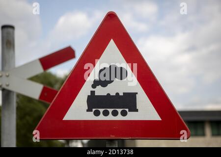 AADORP, PAESI BASSI - Set 07, 2020: Segnale stradale olandese raffigurante un treno che significa che c'è un passaggio ferroviario davanti con cielo blu e nuvole nella ba Foto Stock