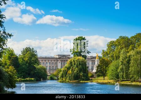 Regno Unito, Londra, Westminster. La facciata di Buckingham Palace e St James's Park e lago Foto Stock