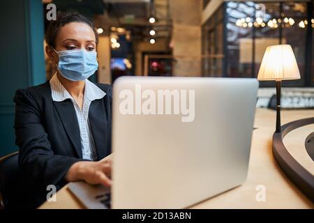 Lavoratore serio seduto di fronte al suo laptop Foto Stock