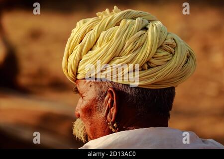 Un ritratto laterale astratto di un uomo Rajasthani che indossa un turbante giallo in Pushkar fare a Pushkar, Rajasthan India il 29 ottobre 2017 Foto Stock