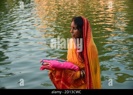 Le donne indiane della classe media inferiore che eseguono pooja di chhath a Delhi.Chhath è un antico festival indù Vedic.Chhath Parva.is celebrato per onorare il sole. Foto Stock