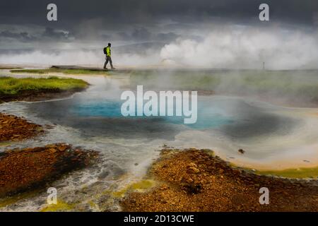 Passeggiate a piedi lungo le piscine colorate nella zona geotermica di Hveravellir. Foto Stock