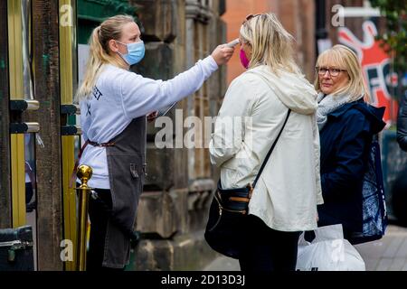 I clienti hanno la loro temperatura al pub 'Rose Street Gardens', che dovrebbe essere influenzato dall'ultimo annuncio del primo ministro scozzese sulle restrizioni covid-19. Credito: Euan Cherry Foto Stock