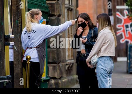 I clienti hanno la loro temperatura al pub 'Rose Street Gardens', che dovrebbe essere influenzato dall'ultimo annuncio del primo ministro scozzese sulle restrizioni covid-19. Credito: Euan Cherry Foto Stock