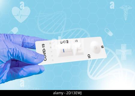 La mano di un medico o di un tecnico di laboratorio mostra un test COVID-19 di laboratorio rapido per rilevare anticorpi IgM e IgG contro il nuovo coronavirus, SARS-COV-2 WIT Foto Stock