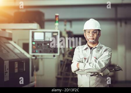 Il lavoratore in una fabbrica uniforme di macchine da costruzione Foto Stock
