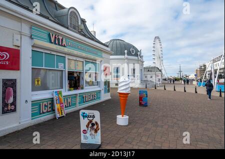 Worthing Waterfront presso il molo con chiosco che vende gelati e dolci e pavillion e ruota di frerris sullo sfondo, West Sussex, Regno Unito. Foto Stock