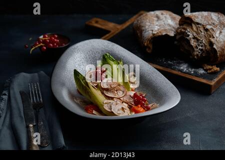 Primo piano sulla cucina tradizionale italiana Vitello tonnato. Un piatto con vitello sottaceto con salsa di crema di tonno e pane su fondo di legno. Spazio di copia per Foto Stock