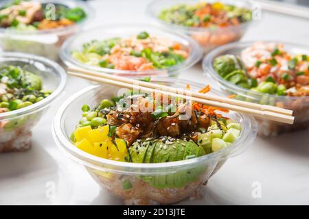 Primo piano di cibo giapponese da asporto, bocce di poke. Foto Stock