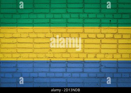 Bandiera nazionale del Gabon raffigurante in colori dipinti su un vecchio muro di mattoni. Bandiera banner su sfondo muro di mattoni. Foto Stock
