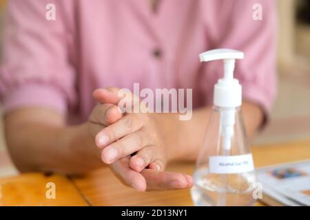 Primo piano donna asiatica con disinfettante per le mani pompando gel di alcol 75% per prevenire il coronavirus o covid 19. Foto Stock