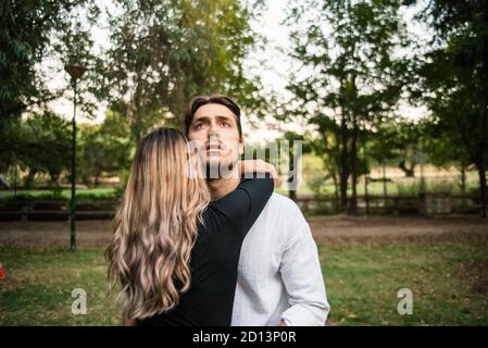 Giovane uomo abbraccia il suo partner in amore mentre pensare circa il suo futuro. Foto Stock