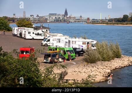 Camper sulle rive del Reno nel quartiere Rodenkirchen, vista sulla città, il porto di Rheinau e la cattedrale, Colonia, Germania. Wohnmobi Foto Stock